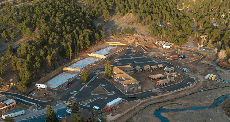 Aerial view of a construction site amid hills and mountains.