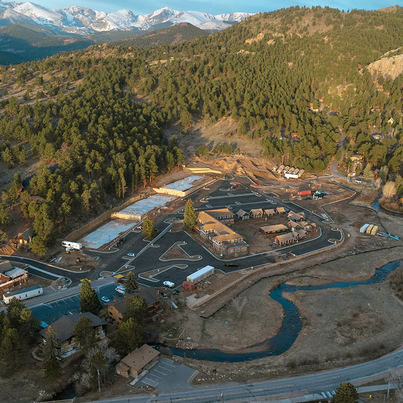 Aerial view of a construction site amid hills and mountains.