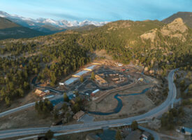 Aerial view of a mountain town with snowy peaks.